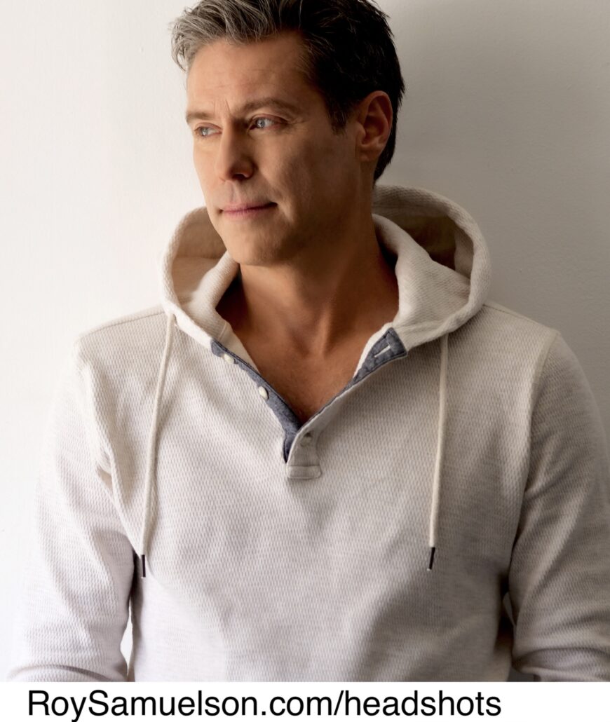 a trim white man with short cut hair wearing a fitted sweatshirt, gazing off to the left with a small smile. Text, Roy Samuelson dot com forward slash headshots